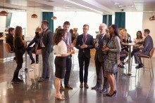 Cocktail style corporte event with 5 people standing in the foreground