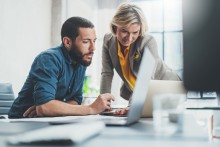 Two people looking at a laptop